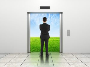 man and modern elevator with opened doors to field